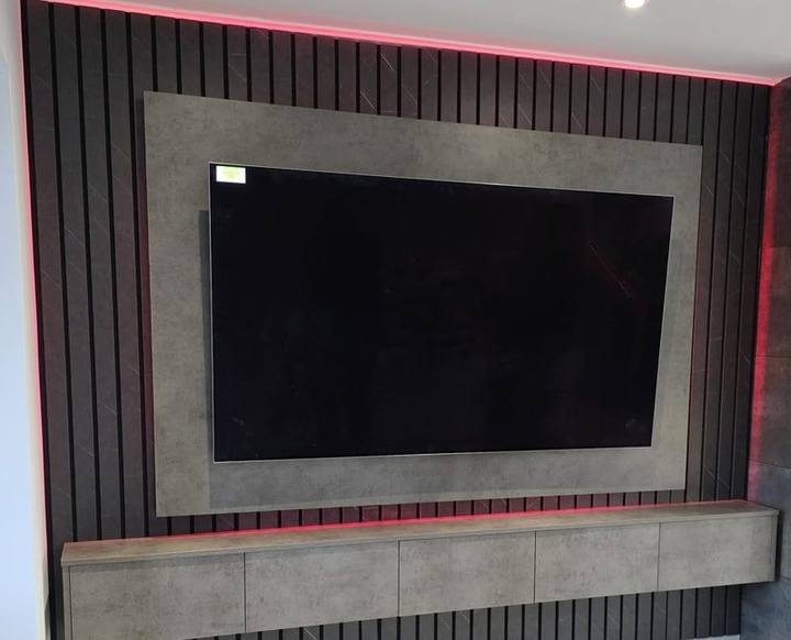Media wall being fitted on a chimney breast with red LED backlighting
