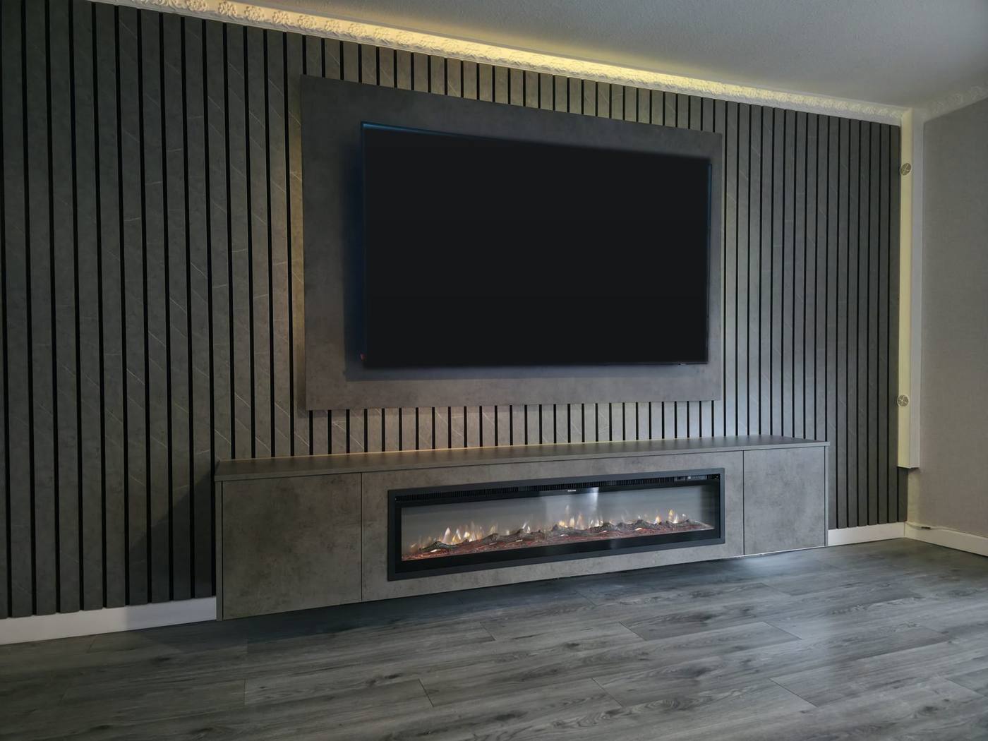 Bespoke dark slat media wall with concrete-effect floating cabinet and log-effect electric fire